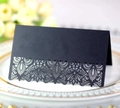 Detail of elegant black laser-cut lace table card on white porcelain plate for wedding - Black