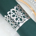 Detail of silver laser-cut floral napkin ring on a dark green cloth and gold-rimmed plate - Reflective Silver
