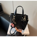 Detail of black faux leather tote bag with animal texture and decorative plaid charm - Black (With Cherry Pendant)