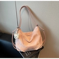 Detail of pink marble pattern tote bag with plush bear charm on a stack of books - Pink