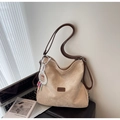 Detailed macro view of beige suede tote bag with brown leather strap and brand patch - Off-white (With Pendant)