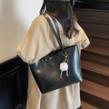 Black leather tote bag variant featuring a creative plush monster charm and long straps - Black (with Pendant)