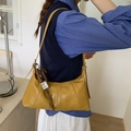 Mustard yellow hobo bag in glossy PU leather with a decorative horse charm pendant - Yellow