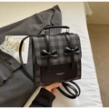 Detail of checkered square bag featuring black decorative bows and leather handle - Black