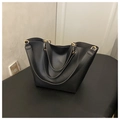 Makrodetail der schwarzen matten Ledershopper mit eleganten goldenen runden Metallringen - Schwarz