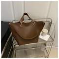 Klassische dunkelbraune Leder-Shopper-Tasche mit goldenen Ringen im schicken Alltag - Braun