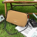 Borsa a tracolla alla moda in nylon marrone con cinturino intrecciato su prato - Marrone