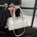 Creamy white pleated Boston barrel bag with silver hardware and removable shoulder strap - Off White