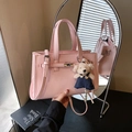 Borsa a mano minimalista rosa chiaro con grana litchi, ciondolo a orso e tracolla - Rosa con ciondolo