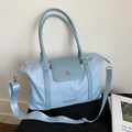 Détail du sac de voyage bleu clair avec boucle métallique et bandoulière réglable - Bleu