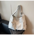 Detail of off-white pleated tote bag showing double front pockets and adjustable strap - Lime White