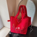 Red embroidered canvas tote bag with colorful floral patterns and matching top handles - Red