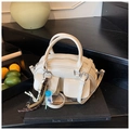 Detailed view of shiny cream crossbody bag with pockets and cute lollipop charm - With Pendant / White