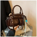 Detailed macro shot of dark brown glossy leather handbag with dual front pockets - With Pendant / Coffee