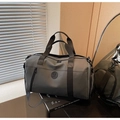 Detail view of grey travel bag with textured fabric and adjustable strap in lifestyle setting - Gray