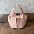 Dettaglio della borsa a secchiello rosa in nylon con design multitasca e texture in tessuto - Rosa Chiaro