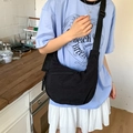 Versatile black crescent crossbody bag with adjustable wide strap and nylon finish - Black