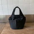 Dettaglio borsa a secchiello nera in nylon con ampie tasche frontali e manici larghi - Blu scuro