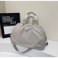 Macro detail of a grey travel bag showing lightweight nylon fabric and dual top handles - Gray