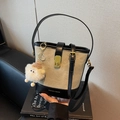 Bucket-Bag aus Segeltuch und schwarzem Leder mit Goldschließe und Plüsch-Anhänger - Weiß-Schwarz-Patchwork Mit Anhänger
