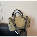 Detail view of olive green waterproof nylon travel bag with durable black handles - Green