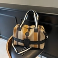 Striped yellow and brown large travel tote bag with black straps on a chair - Brown