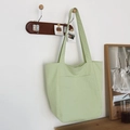 Minimalist light green tote bag with front pocket hanging on a wooden wall hook - Light Green
