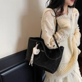 Minimalist black tote bag with wrinkled texture and cute bear charm shown on model - Black