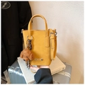 Gros plan d'un mini sac bandoulière jaune avec un ours en peluche sur des livres - Jaune avec Pendentif