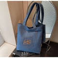 Detail of blue denim tote bag featuring dual pockets and yellow today mood embroidery - Blue