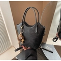 Dettaglio borsa a secchiello nera con bordo ondulato, ciondolo peluche e logo dorato - Con Ciondolo / Nero