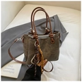 Detail of vintage bucket bag featuring brown leather handles and woven knot decorative charms - Black with Pendant