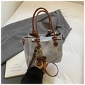 Close-up of light blue denim bucket bag with brown bow detail and metal beads - Blue with Charm