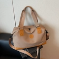 Canvas travel bag with leather accents and adjustable shoulder strap in earthy brown tone - Khaki