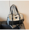 Detailed view of gray and black crossbody travel bag with buckles on a leather sofa - Light Gray