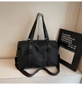 Detail der schwarzen Nylon-Reisetasche mit Doppelgriffen, Gurt und rundem Logo - Schwarz