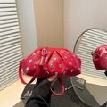 Red dumpling shoulder bag with silver rivets and litchi texture in a lifestyle mirror shot - Red