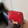 Vibrant red leather crossbody bag with silver hardware and chic studded strap detail - Red
