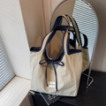 Bolso tote beige minimalista con ribete azul marino y detalle de lazo frontal - Caqui