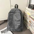 Detail of grey camo waterproof backpack with front zipper pocket and fabric label - Gray