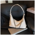 Macro detail of creamy white leather hobo bag with silver chain straps on leather chair - White
