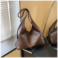 Close-up of deep brown tote bag with pleated leather texture and gold logo detail - Brown