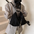 Détail d'un sac à dos noir polyvalent avec anneaux dorés et design asymétrique moderne - Noir