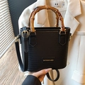Black woven shoulder bag with bamboo handle and adjustable gold strap for summer style - Black