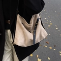 Vue de rue d'un sac cabas en daim beige avec des lanières en cuir noir et métal doré - Kaki