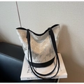 Detail view of the butterfly print on this high-capacity canvas bucket shoulder bag - White and Black