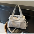 Macro view of grey travel bag featuring NINGJIA embroidery and premium nylon texture - Gray
