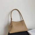 Detail of light brown hand-woven leather bucket bag with a cylindrical shoulder strap - Khaki