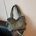 Dark green matte leather tote bag with silver rivets and metal rings on a black chair - Dark Green