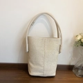 Minimalist beige woven bucket bag with smooth leather trim and wide handle design - Off White